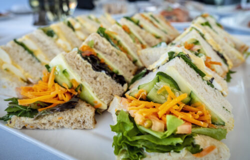Freshly prepared sandwiches arranged on a large plate ready for serving. The arrangement forms part of a catering concept.